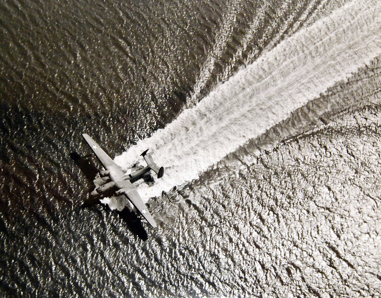 WWII-Aircraft. A Martin “Mariner” leaves a white-ribbon wake as it lands on the harbor of an East Coast Naval Air Station.