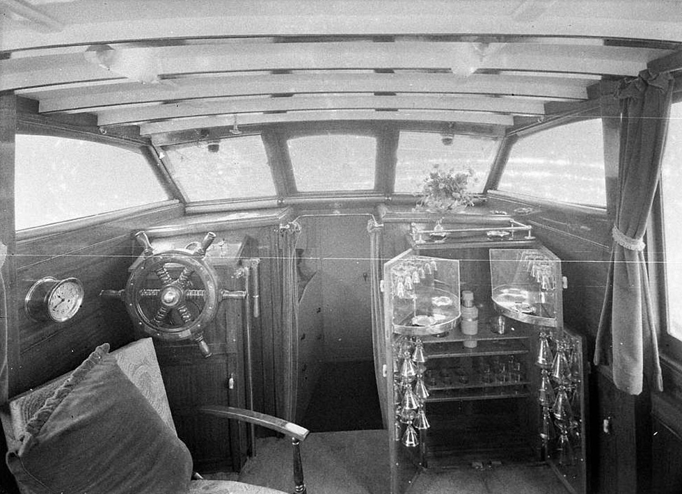 Lounge and wheelhouse with ship's wheel and bar on the cabin cruiser.