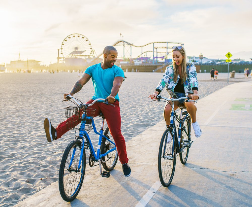 Couple having fun riding bikes together at Santa Monica California