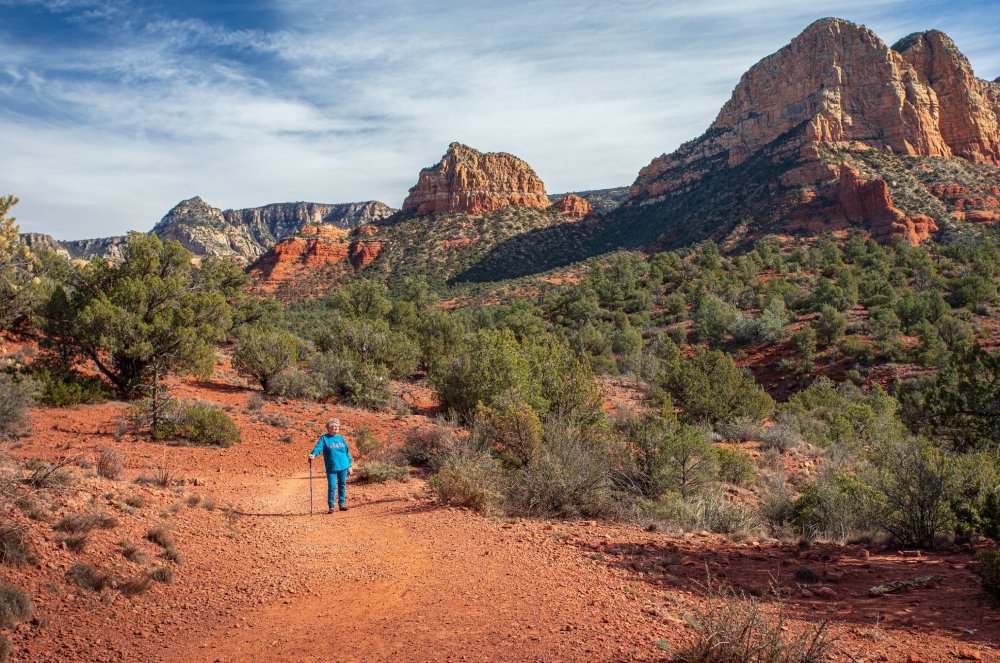 Elderly woman in blue outfit hiking on Sedona, Arizona trail