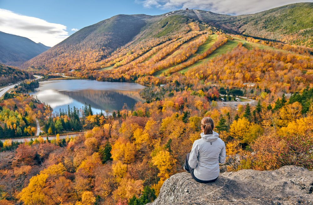 Woman hiking at Artist's Bluff in autumn. View of Echo Lake.