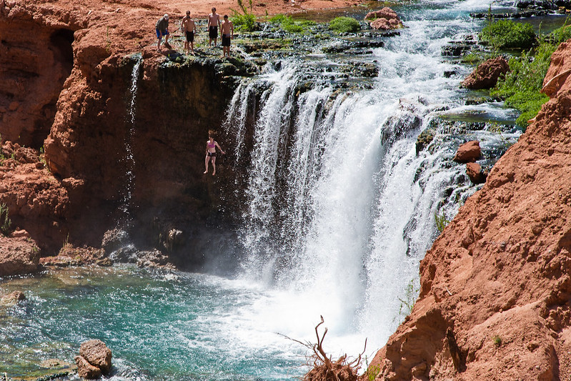 Girl jumping off one of the waterfalls Havasupai Indian Reservation, Grand Canyon, Arizona