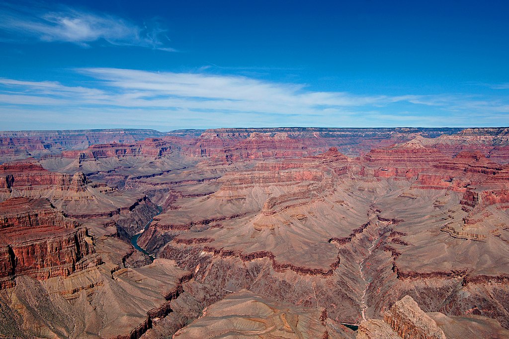 The ruggedness and deep hues of the Grand Canyon are displayed against a deep blue sky.