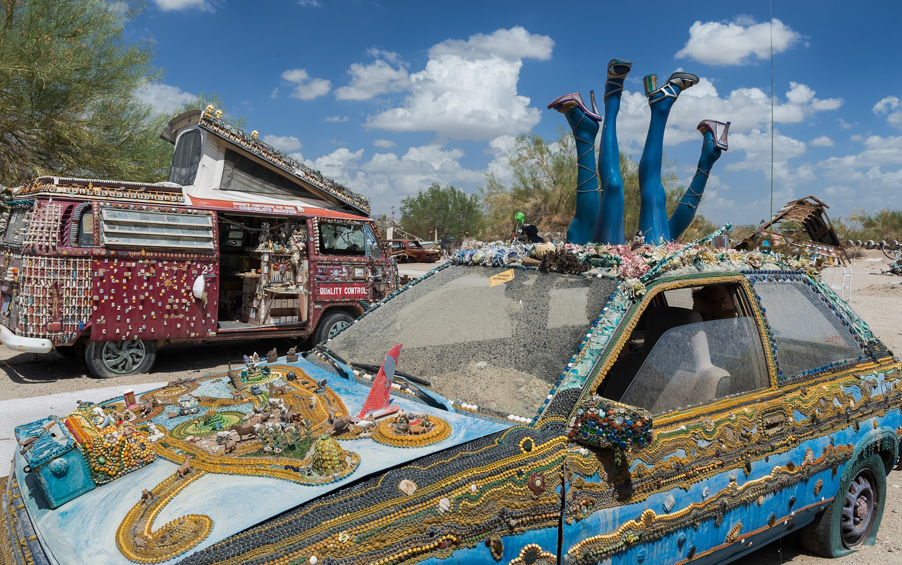 NILAND, CALIFORNIA - AUGUST 10: Decorated car and van in the desert in Slab City on August 10, 2016 near Niland, California