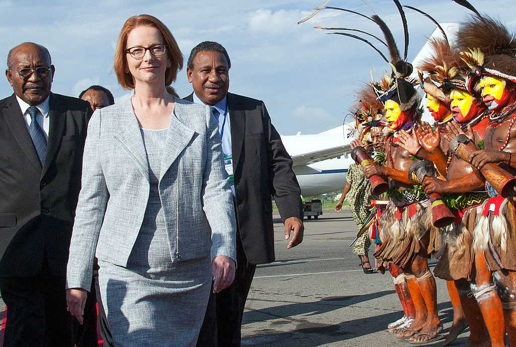 Men from the Huli Wigmen tribe (R) welcome Australian Prime Minister Julia Gillard