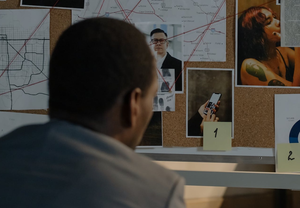 Police detective is looking at pictures.