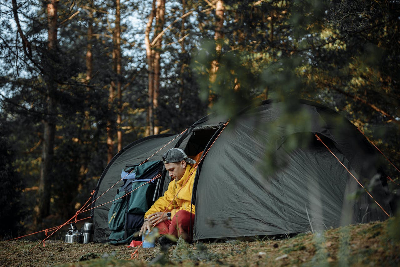 Man sitting inside a tent in the woods