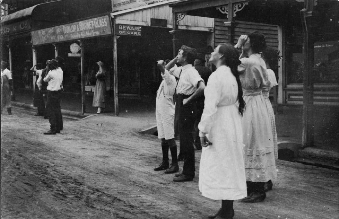 People looking up to the sky, watching the first aircraft ever to fly over Townsville, ca. - 1912