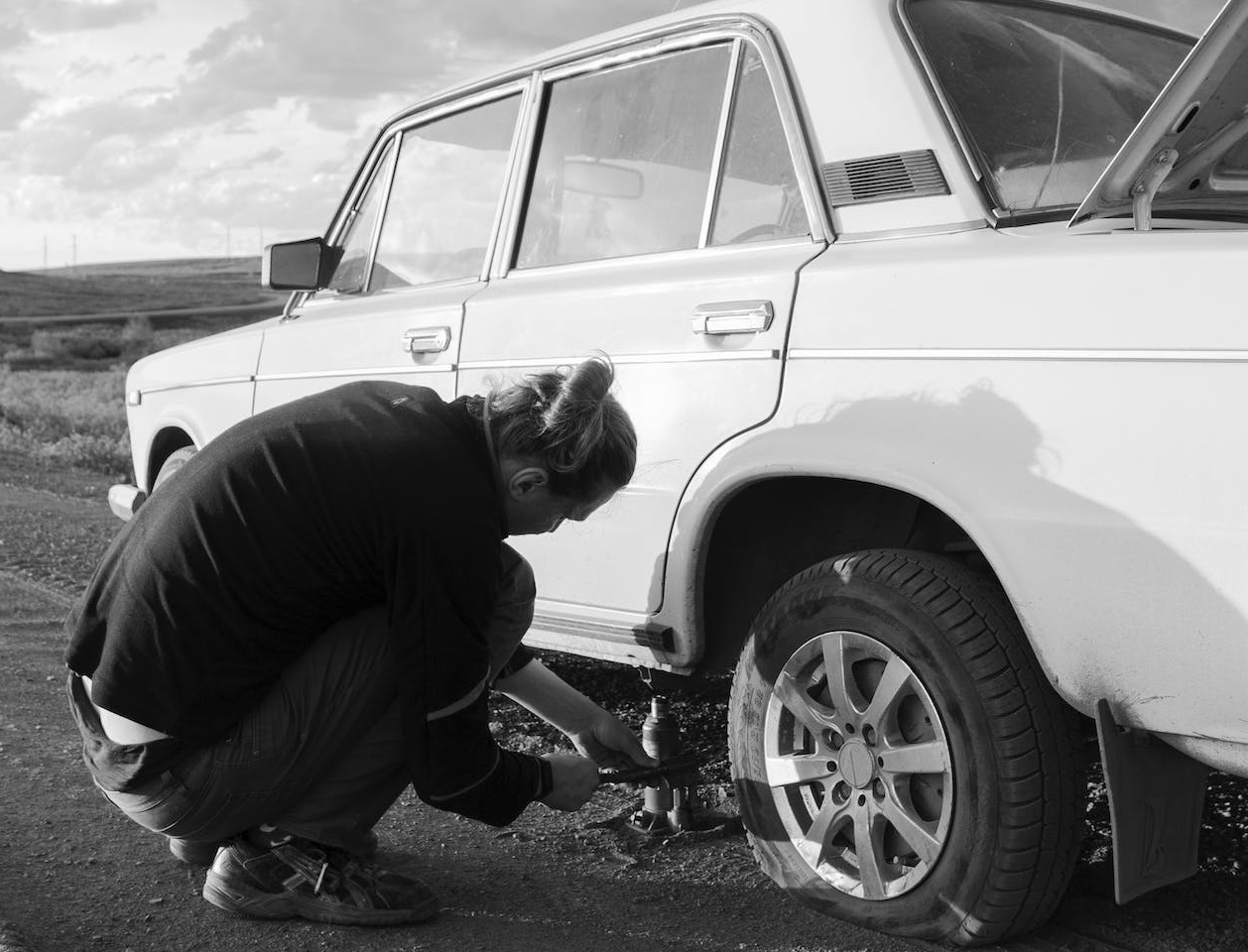Woman on the road with flat tire.