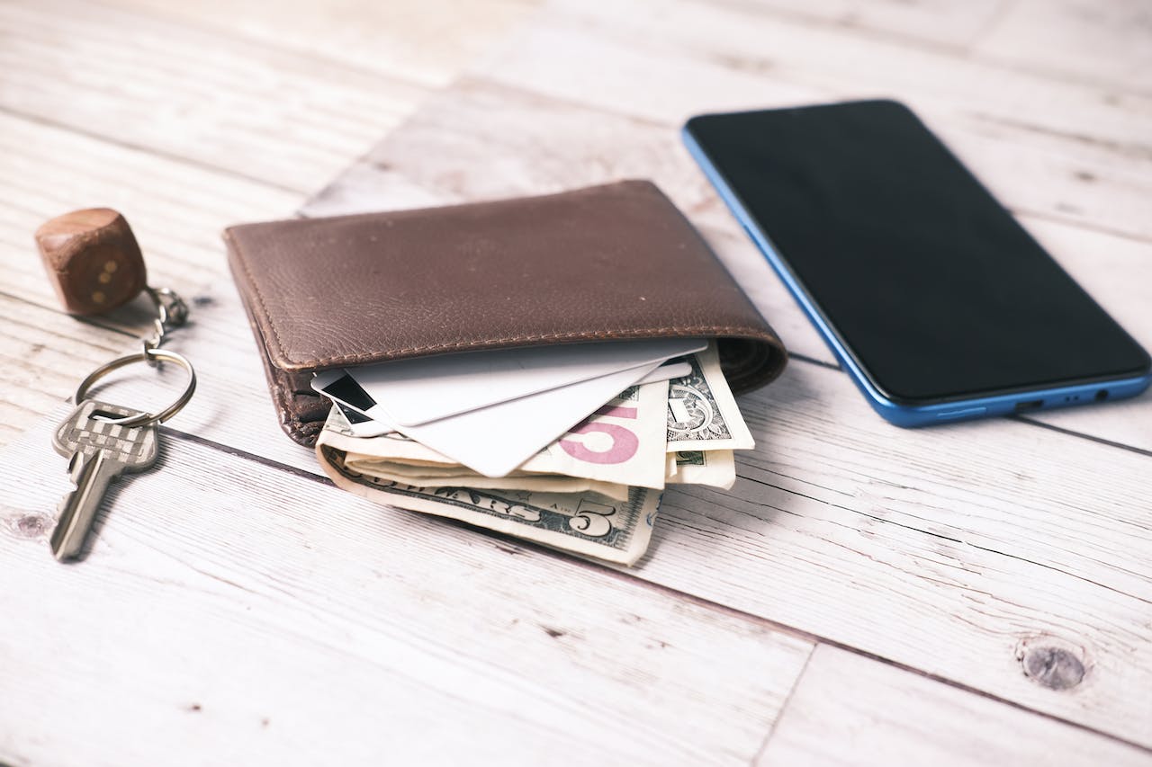 Key ,wallet with cash and smartphone on the table.