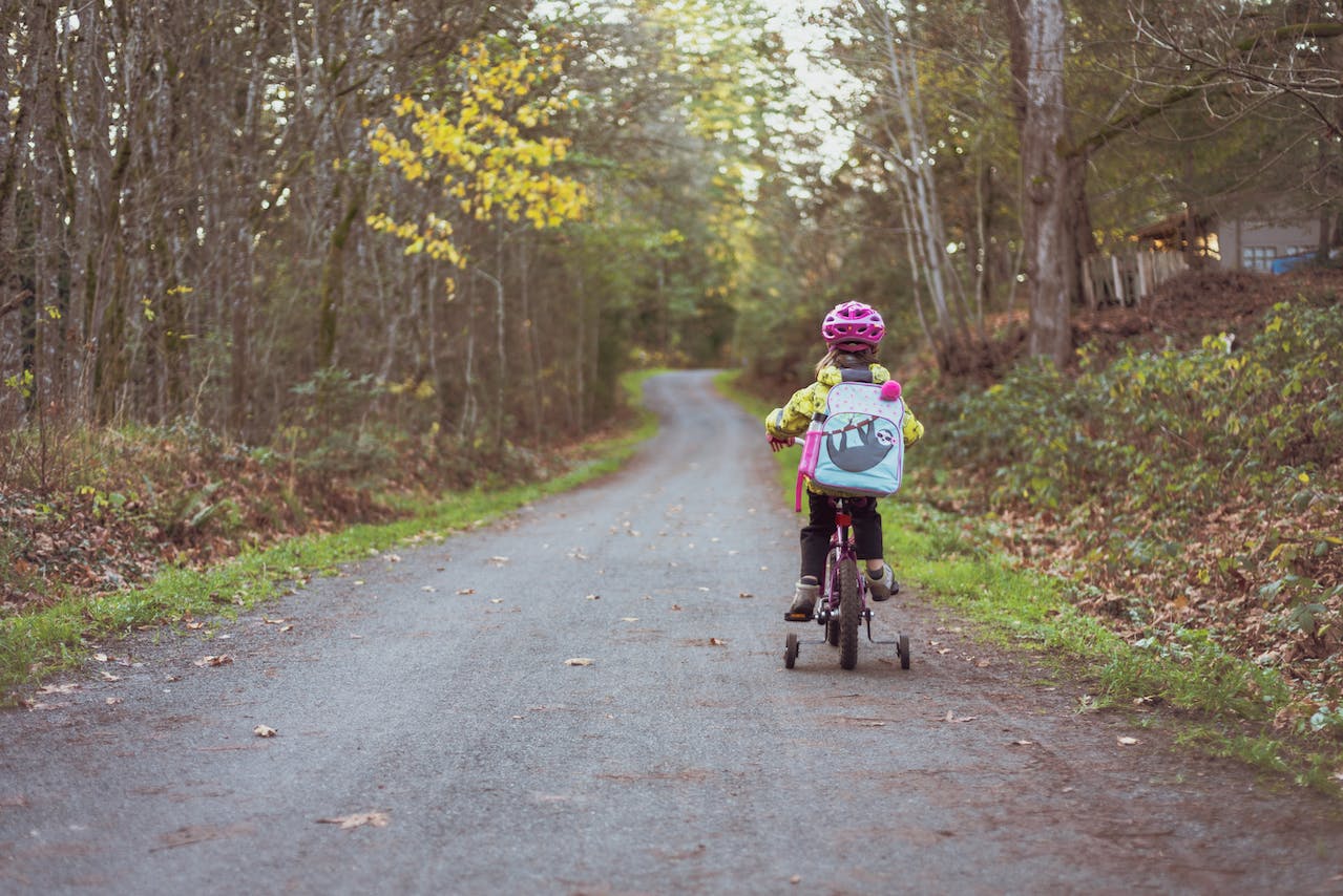 Girl is riding a bike outside.