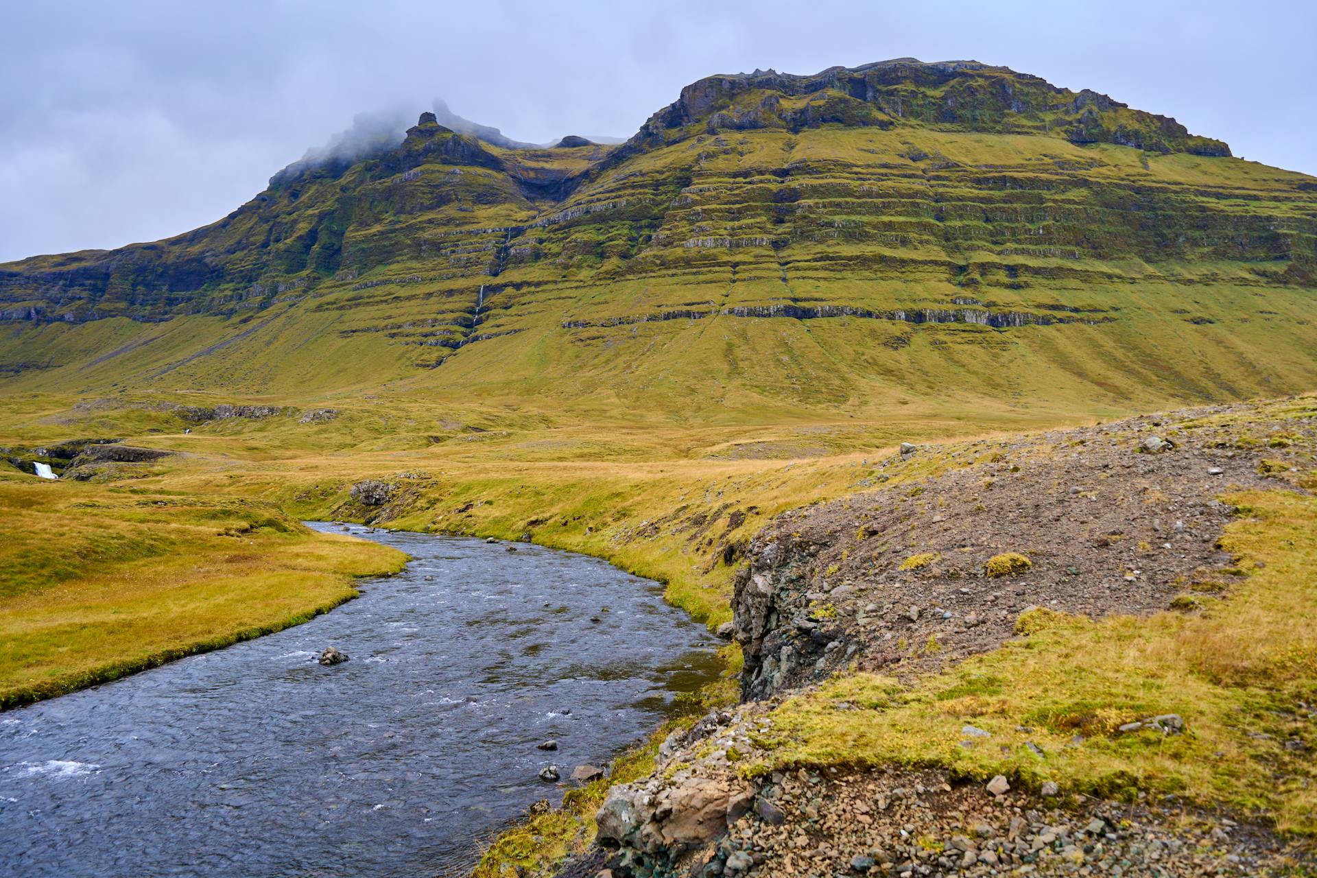 Icelandic landscape of hills and a river.