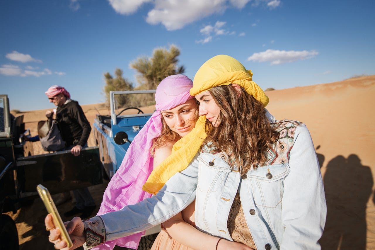 Two women wearing head scarf are taking selfie together.