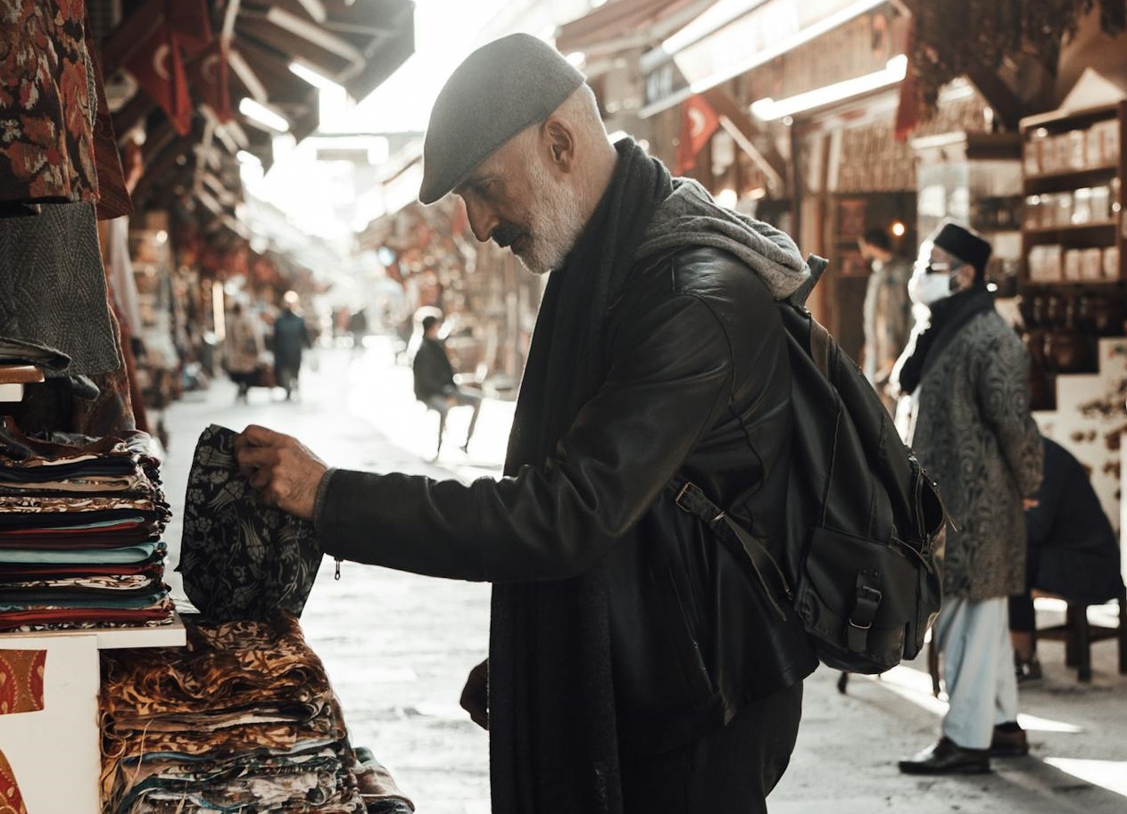 Senior man is buying from street seller.