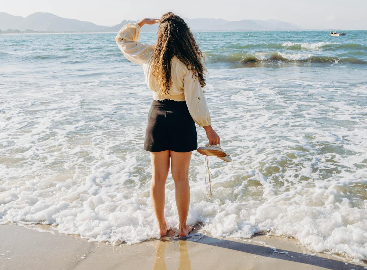 Woman with soaking feet in the sea.