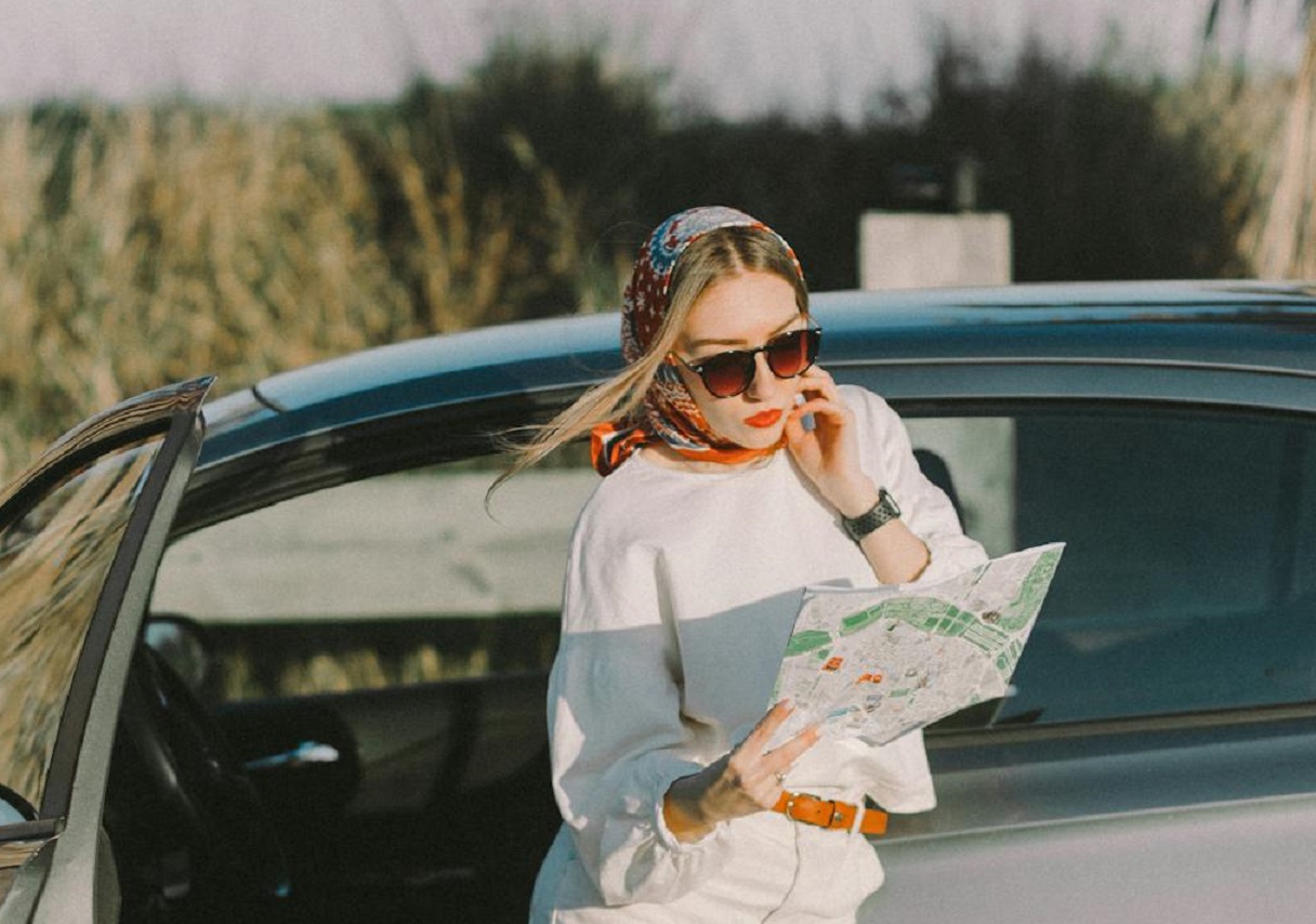 Young woman is looking in map outside.