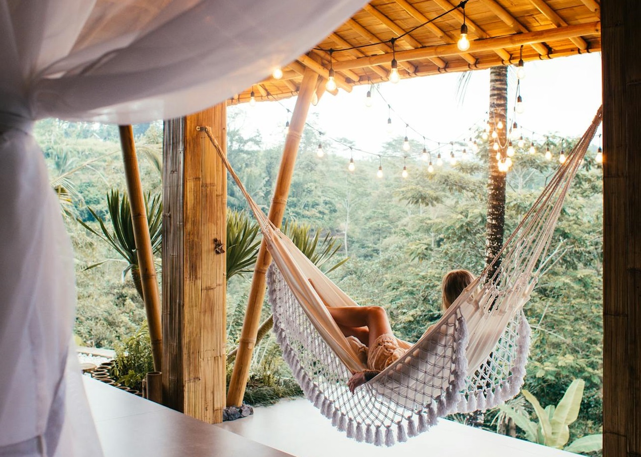 Female traveler in hammock bed in tropical resort.