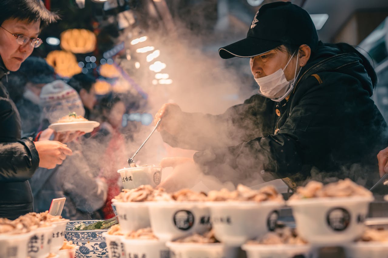 Man is selling street food in cups.
