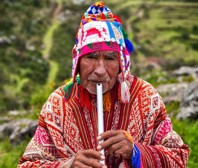 The old man Quechua dressed in a colored poncho and a cap