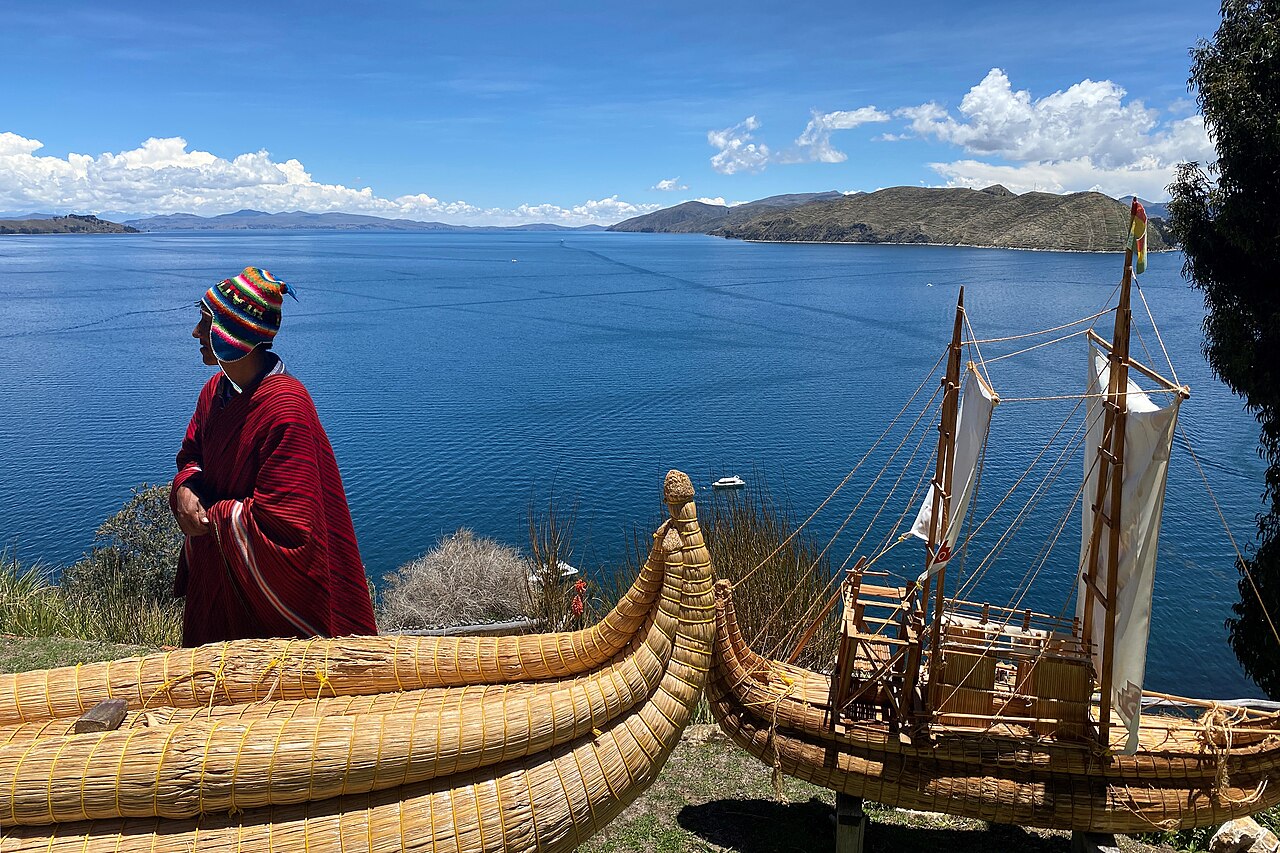 An Aymara man next to a boat made from totora at Lake Titicaca, Bolivia - 2021