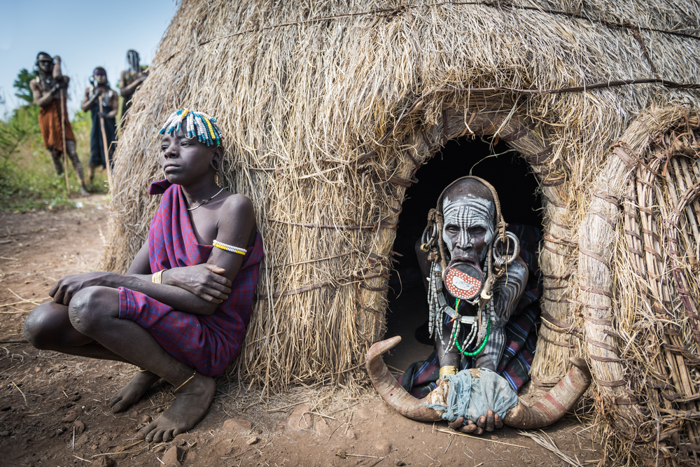 unidentified women from Mursi tribe in front od a hut