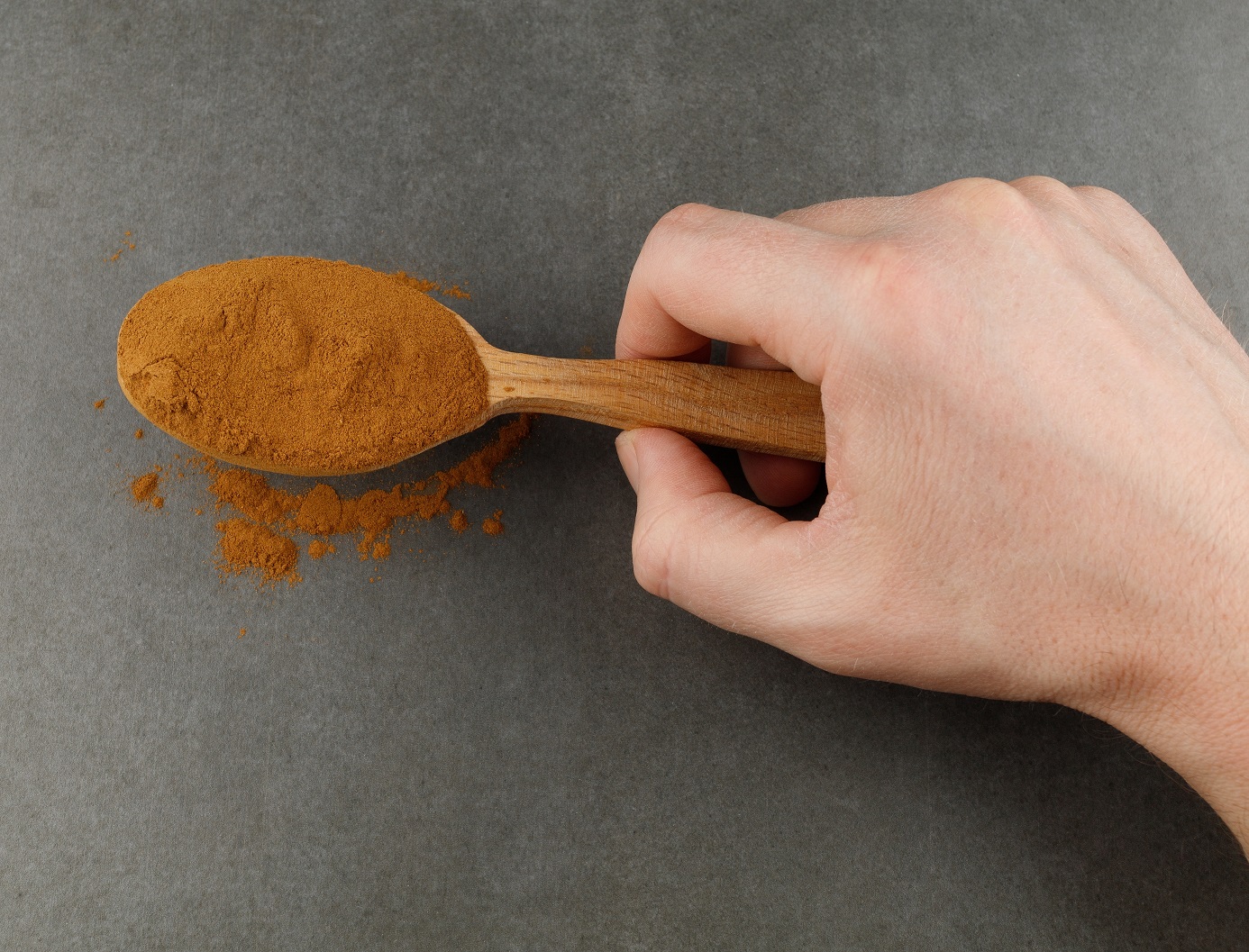 Ground cinnamon in the spoon in the hand