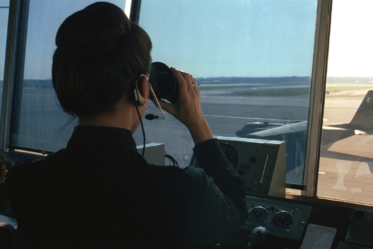 An air traffic controller checks the flight line with binoculars - 1984