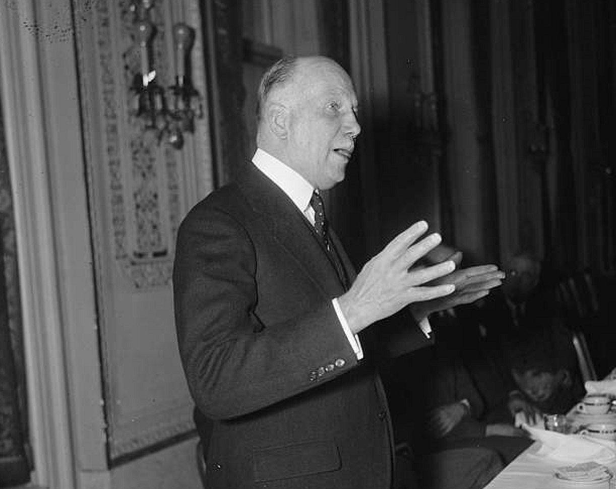 A black and white photo of a man in a suit - 1900/1940.