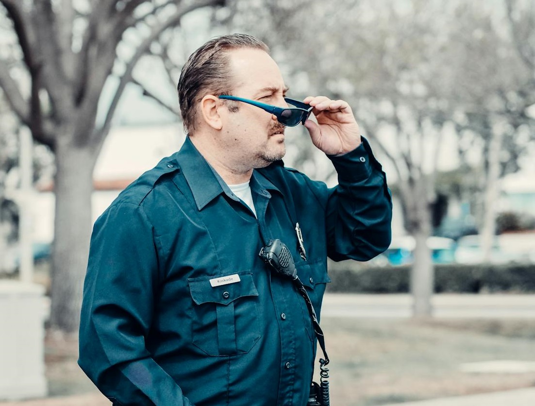 Surprised policeman wearing sunglasses standing surprised.