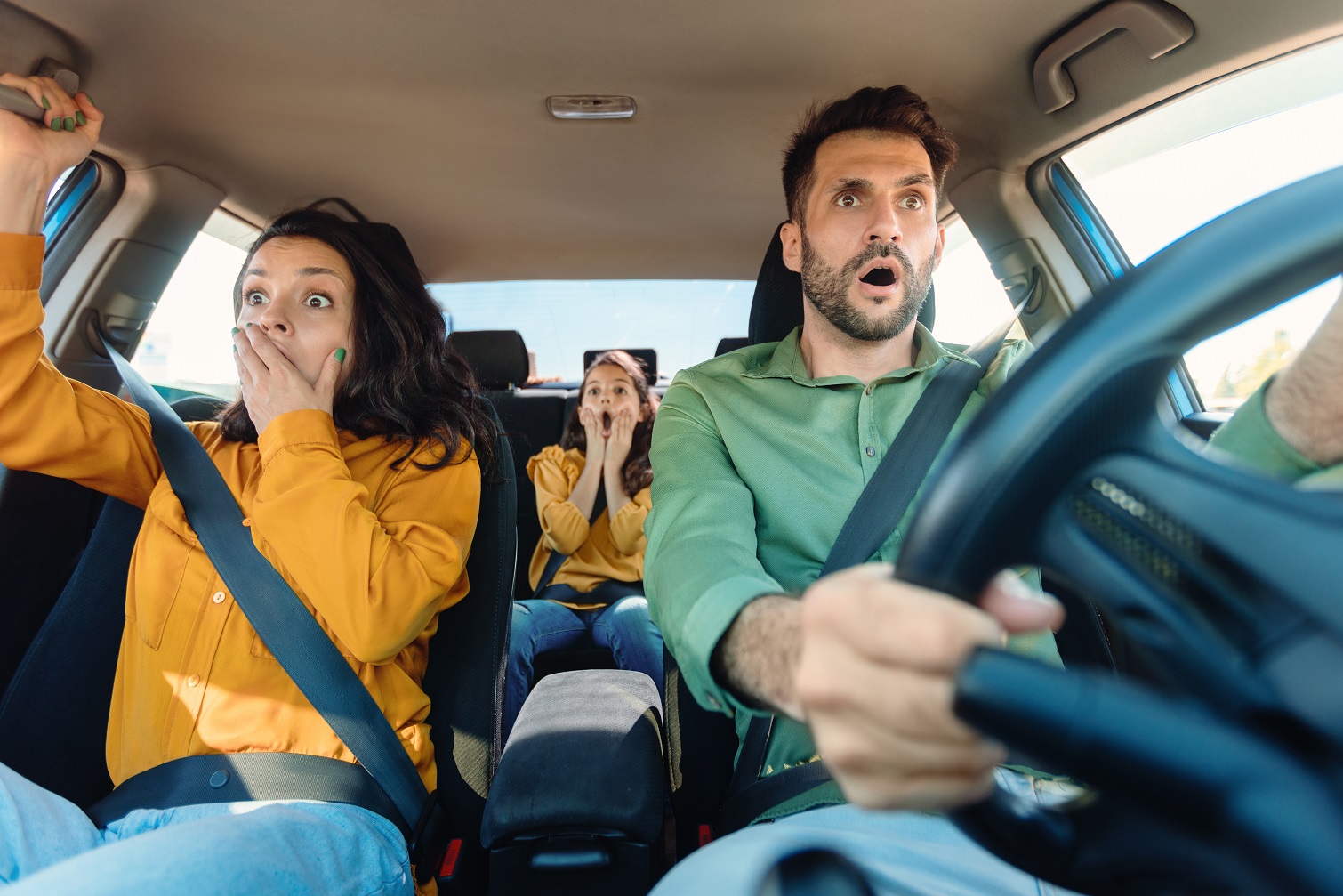 Scared husband, wife and child girl in car cabin during incident.