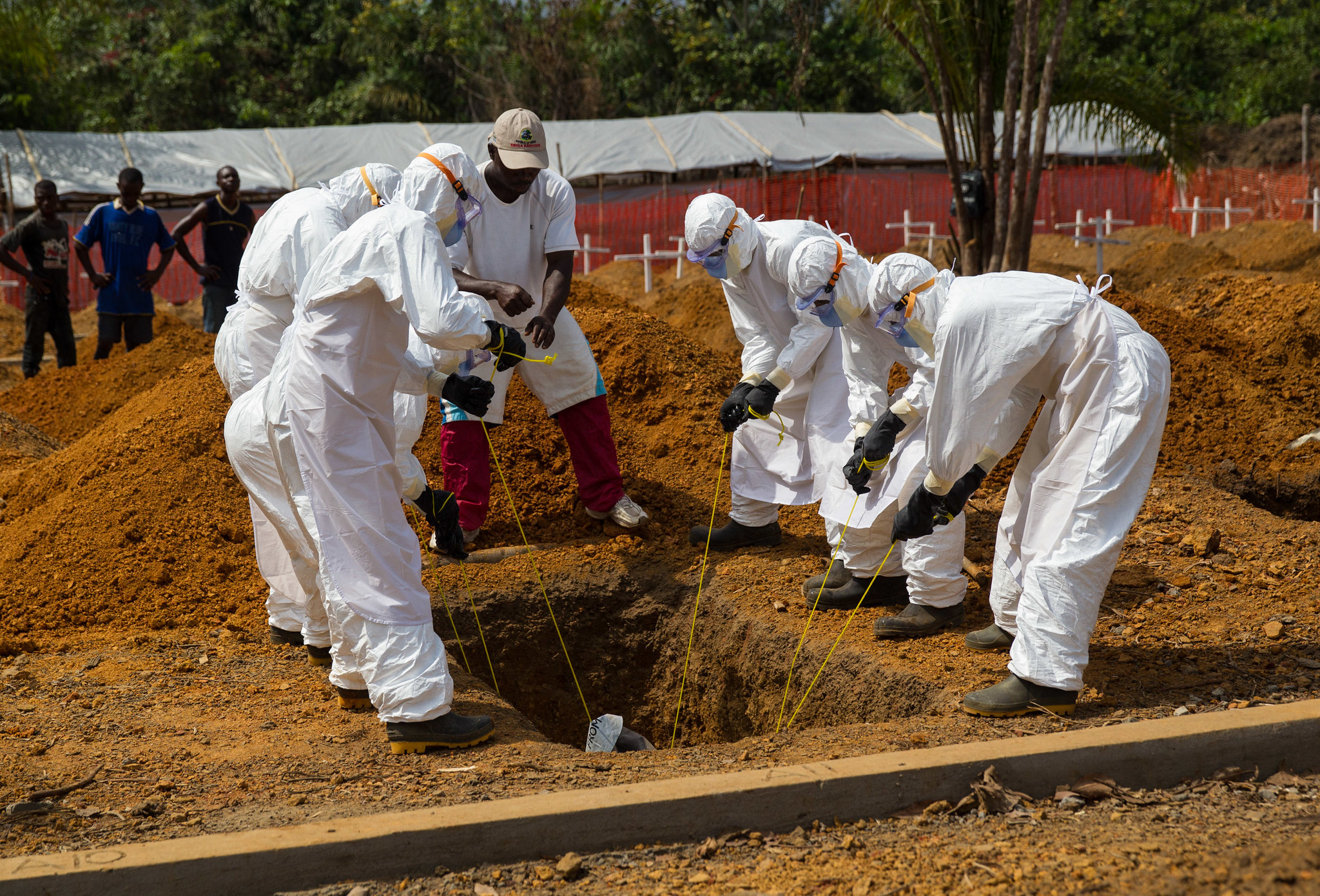 A burial team is lowering the body in cemetery - 2015