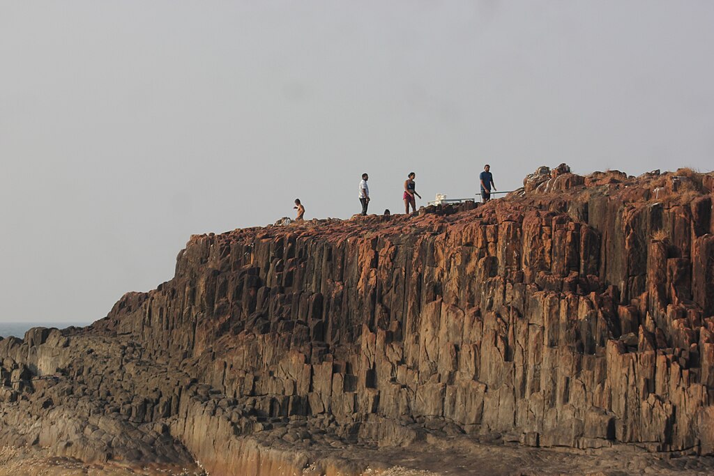 Picture of people standing on the Basalt rock formations on on St. Mary's Islands.