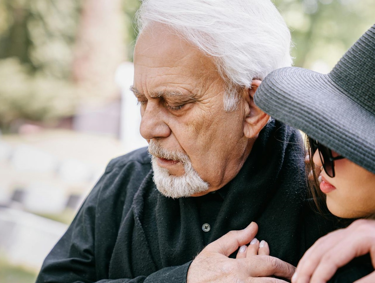 Man and woman hugging each other at funeral.