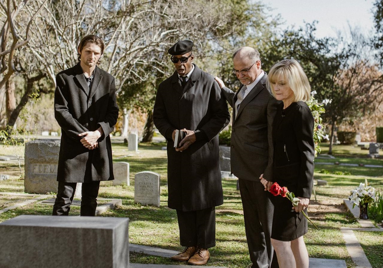People standing before a grave.