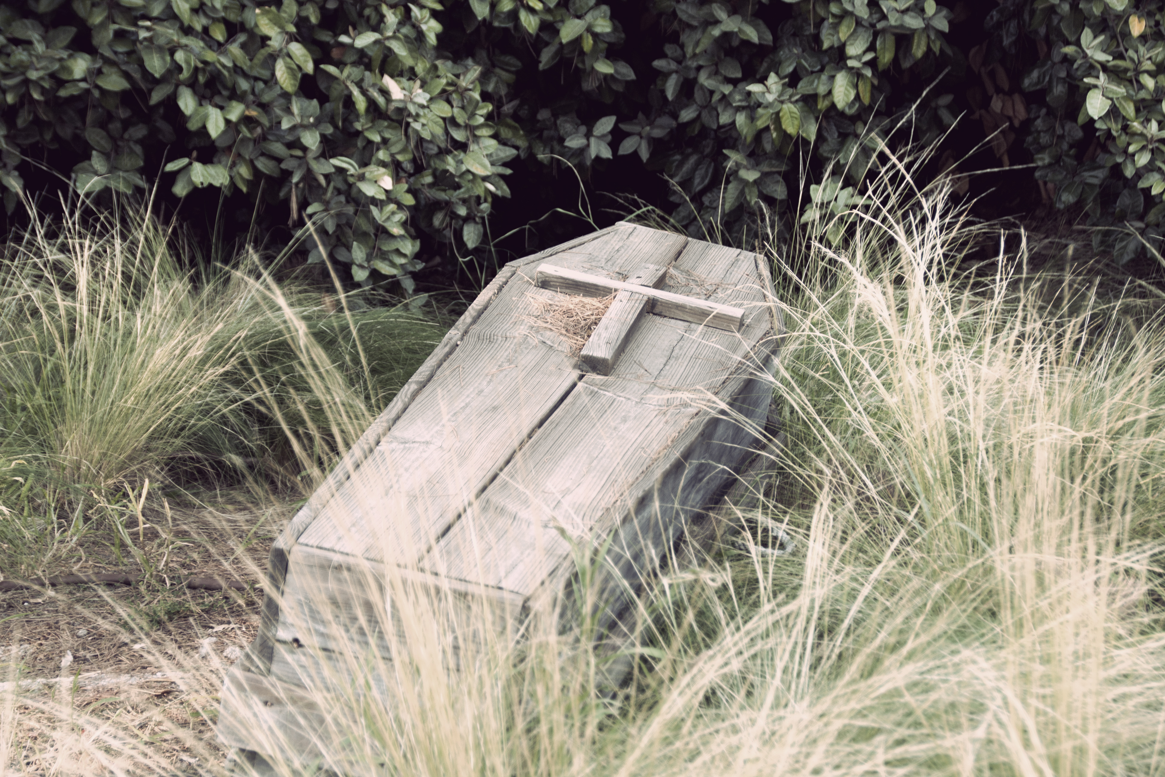 An old wooden coffin with a cross on top.