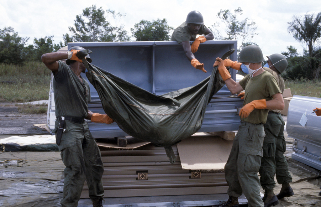 Military personnel place a body bag - 1978