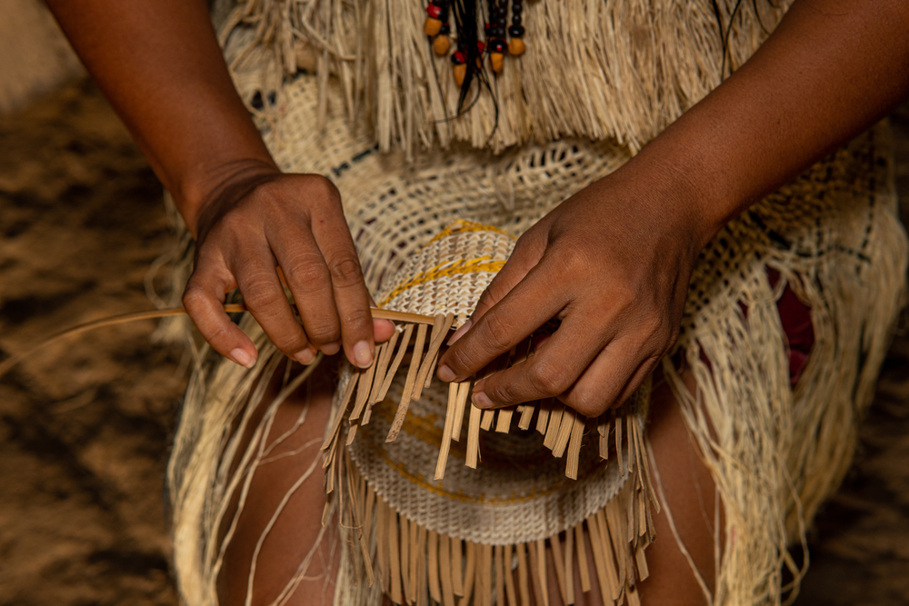 Hands of indigenous woman making traditional basket