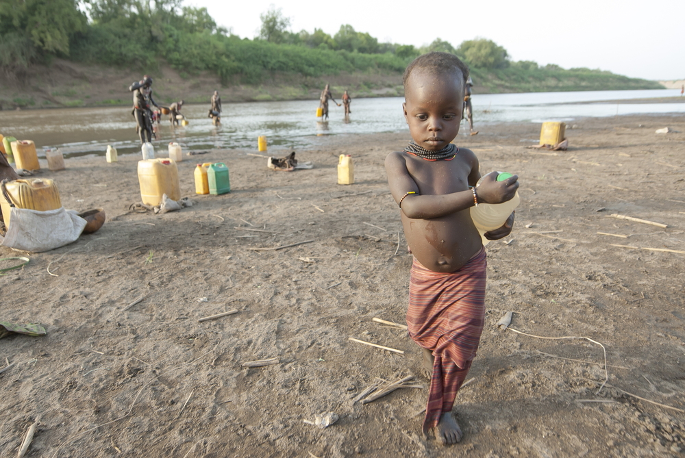 Unidentified Karo girl carries bottle of water