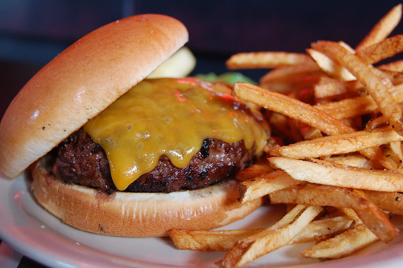 Close-up Photo of cheeseburger and fries placed on a white plate