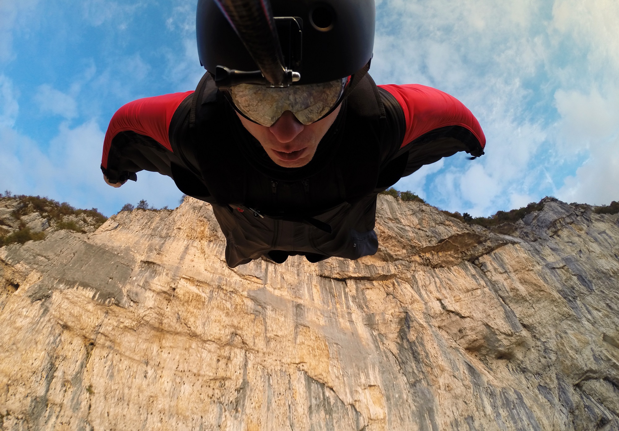 Self-portrait of the base jumper in flight from the cliff, base jumping, wingsuit.