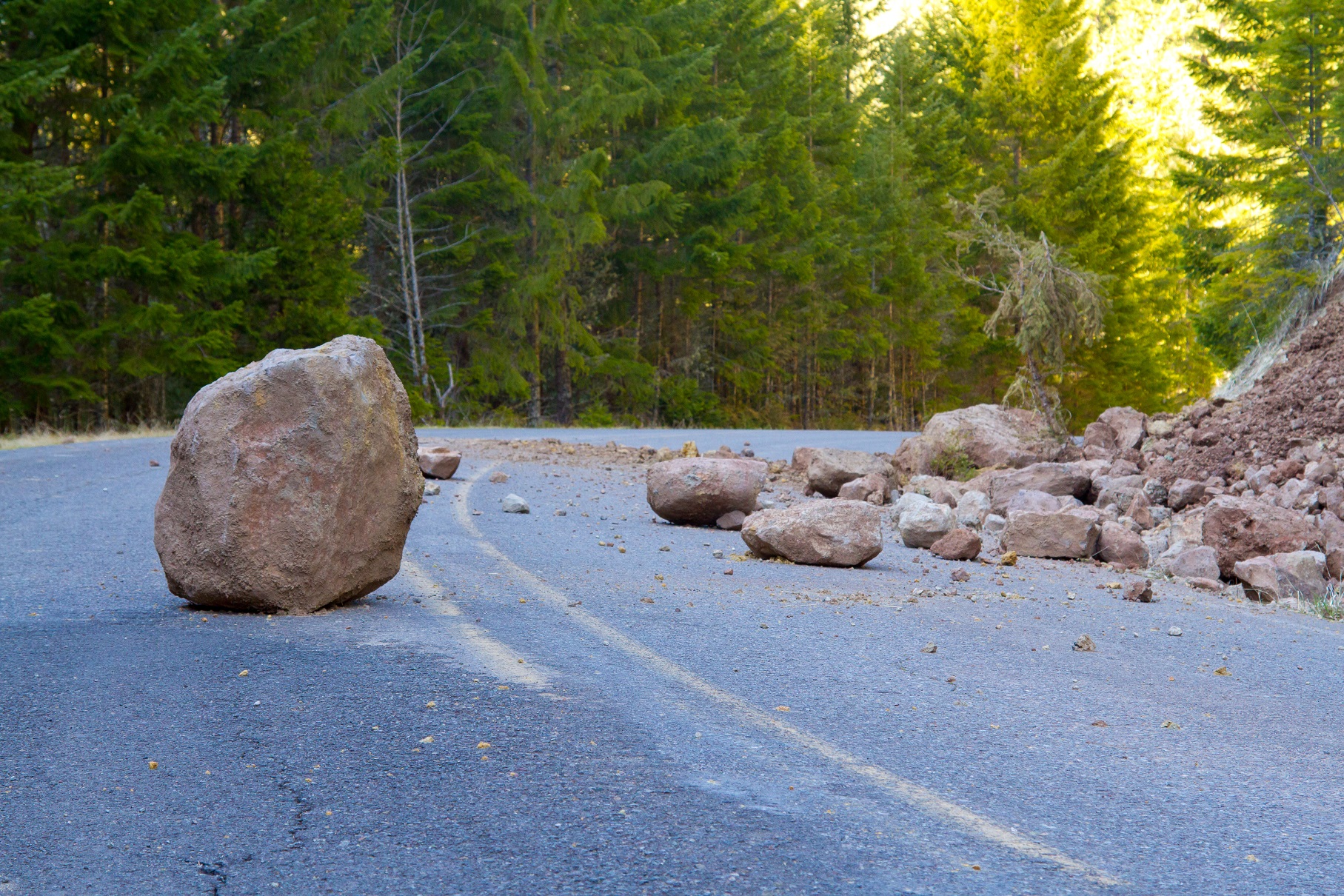 This national forest road is blocked by a land slide of rock and debris.