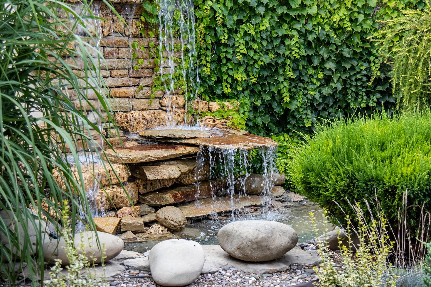 A small decorative waterfall in the garden. Landscape design