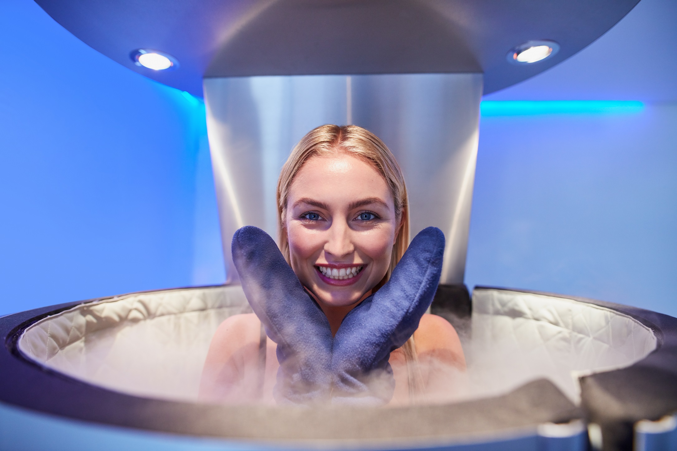 Portrait of a cute young woman in cryo sauna booth for full body cryotherapy.