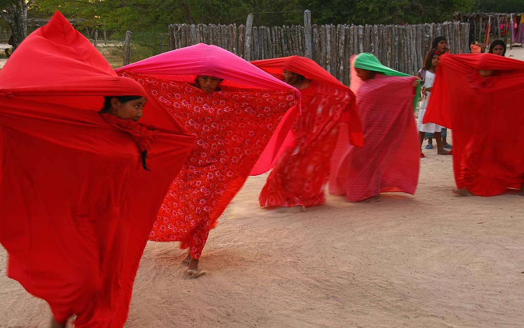 Wayuu women dressed in traditional red outfit dancing