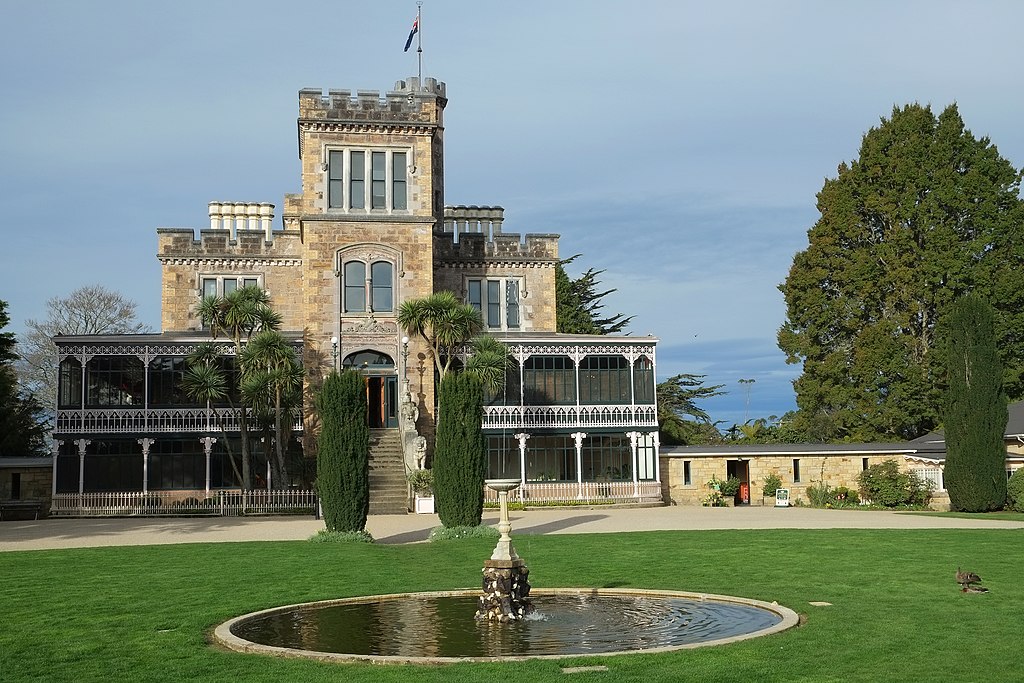 Larnach Castle and front lawn with water fountain in city of Dunedin, New Zealand