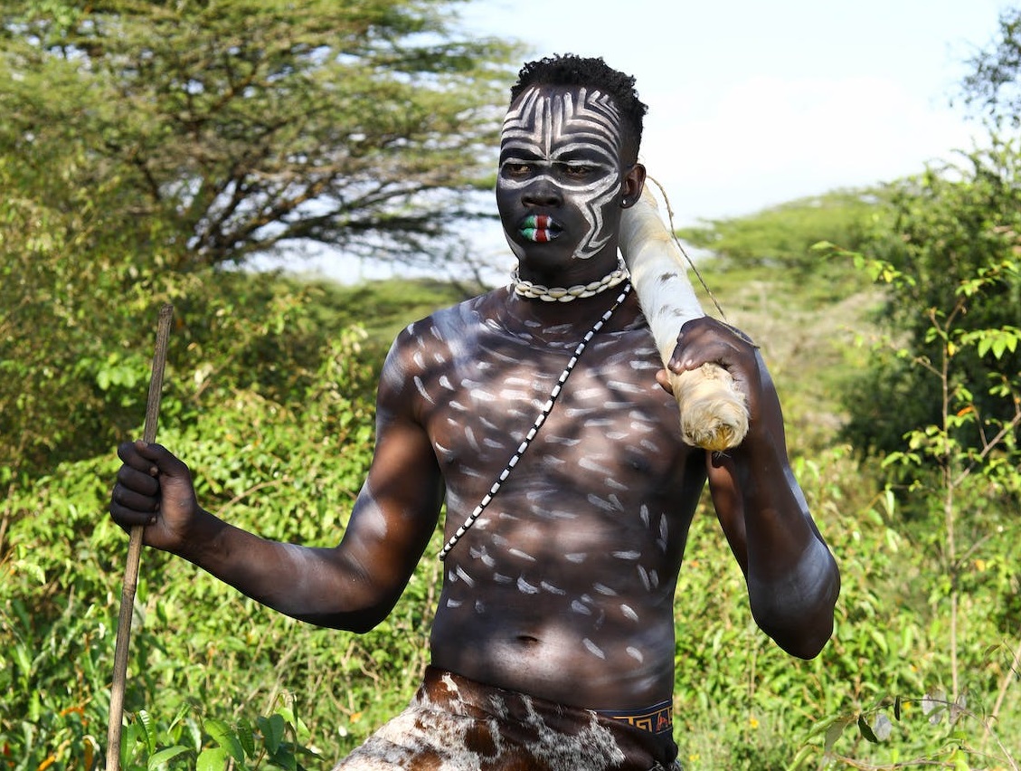Tribe man having his body painted.