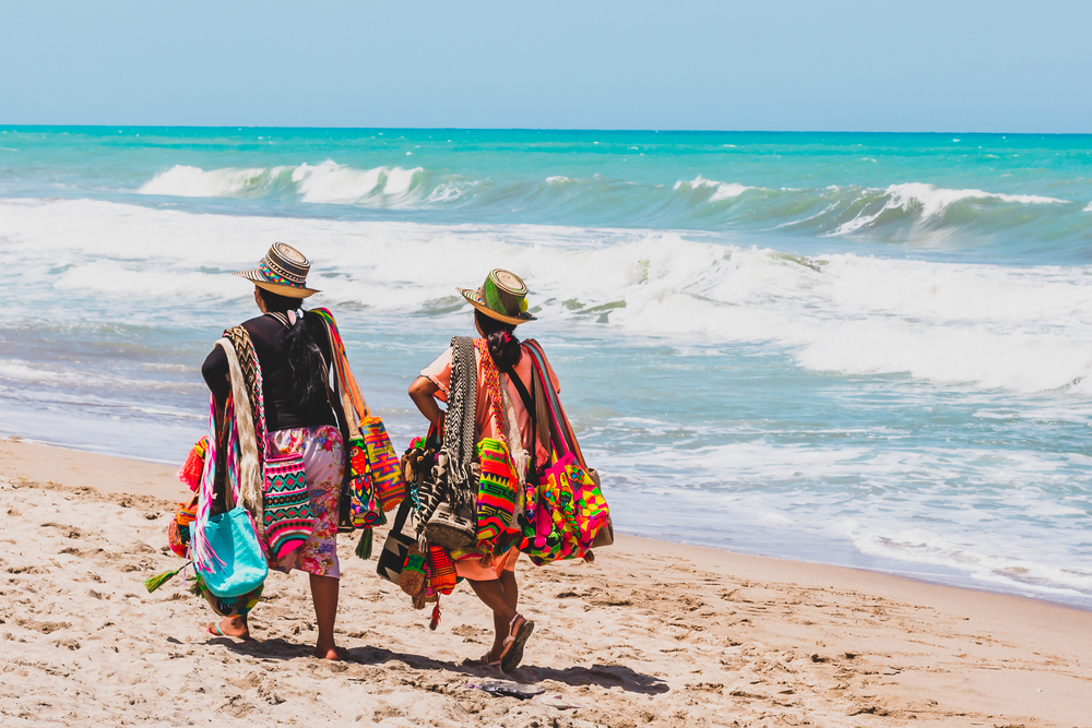Two wayuu women selling their handmade products on the beach