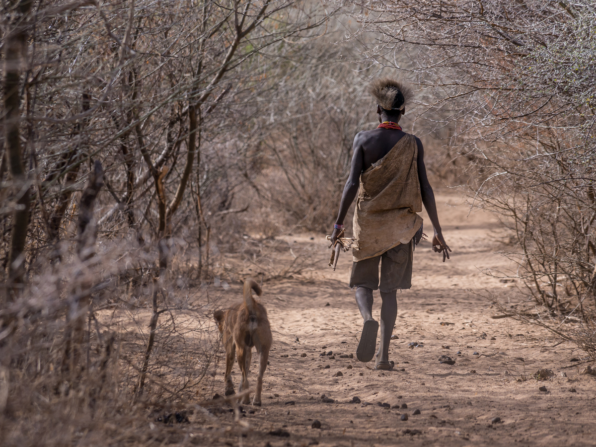 Tribe man with dog walking.