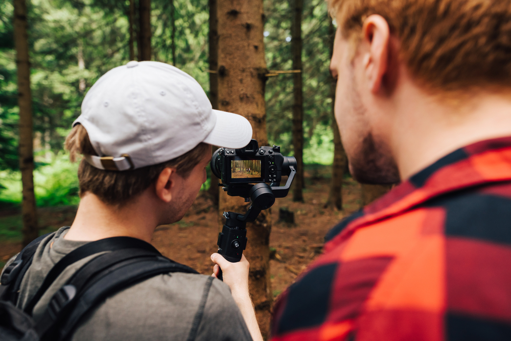 Two men film videos in forest