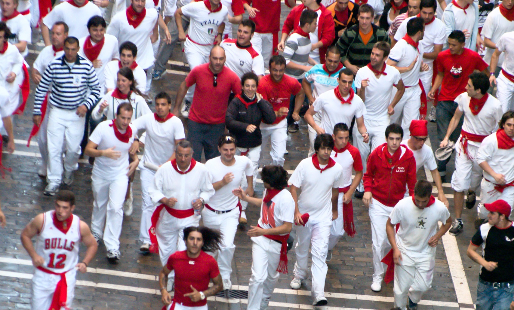People running on the street during the festival of San Fermin.